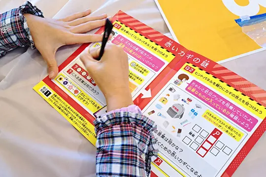 ワークショップの流れの受付で「ハンドブック」を受け取っている画像