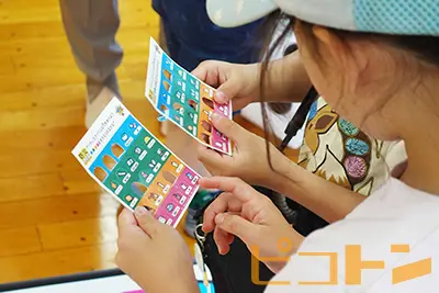 『巨大防災スゴロク』の「ビンゴカード」を楽しんでいる子供たちの様子