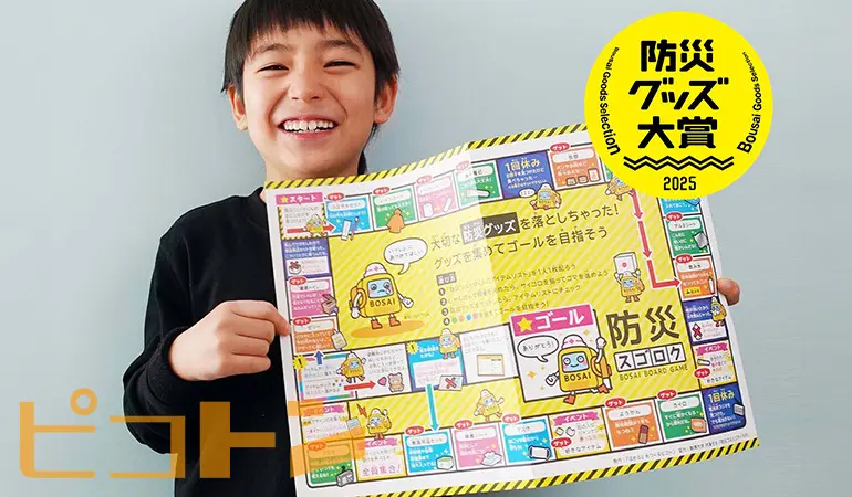 防災グッズ大賞受賞の『防災スゴロク』を嬉しそうに持っている男の子の写真