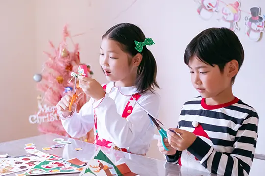 くるっと工作ブック〜クリスマスver.〜を作っている子供たちの写真
