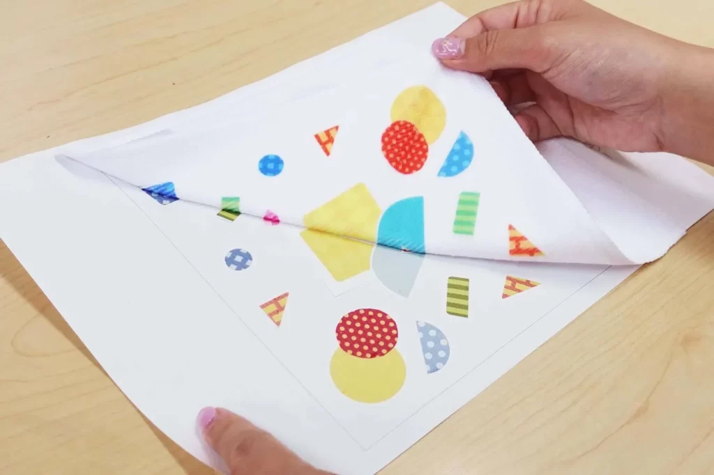 『アートタオル』に熱圧着した転写シートをタオルから剝がす様子。