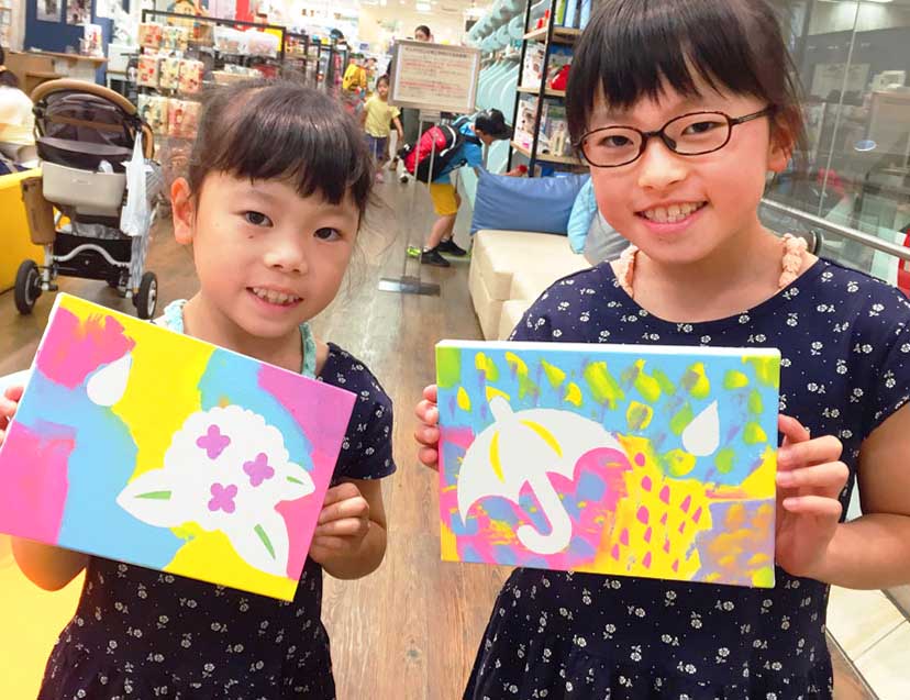 キャンバスと絵の具で作る「アートパネル」梅雨ver.の完成品を持つ女の子2人