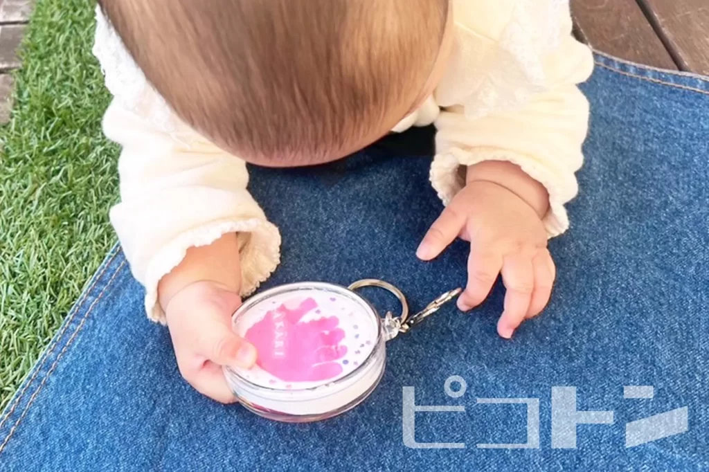 100均グッズで作る足形アートキーホルダーを持つ赤ちゃん