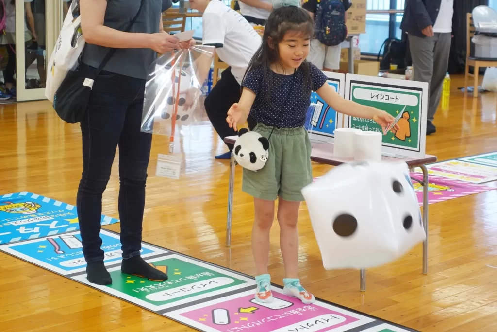 大きなサイコロを振る女の子