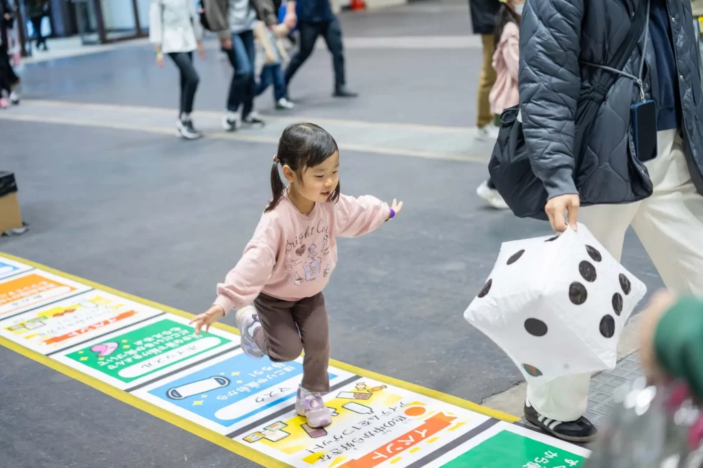 巨大防災スゴロクのマスを進む女の子