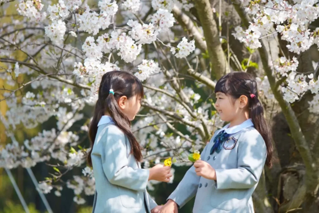 桜の木の前で遊ぶ姉妹