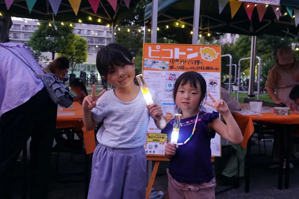 中野チルナイトピクニックにて完成した光る工作を持ってポーズを取る姉妹