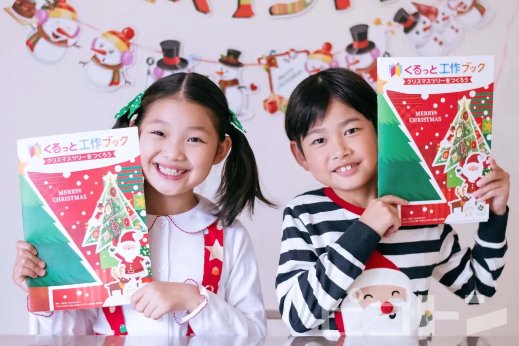 『くるっと工作ブッククリスマスver.』の表紙を持つ女の子と男の子