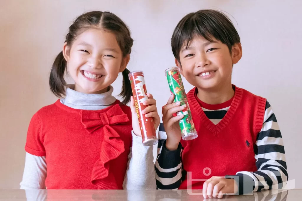 『クリスマス宝石万華鏡』を持つ女の子と男の子