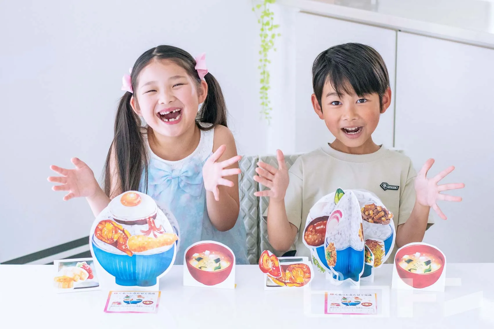 『くるっと工作ブック～カラダをつくる3つのパワー～』の完成品を見せる女の子と男の子