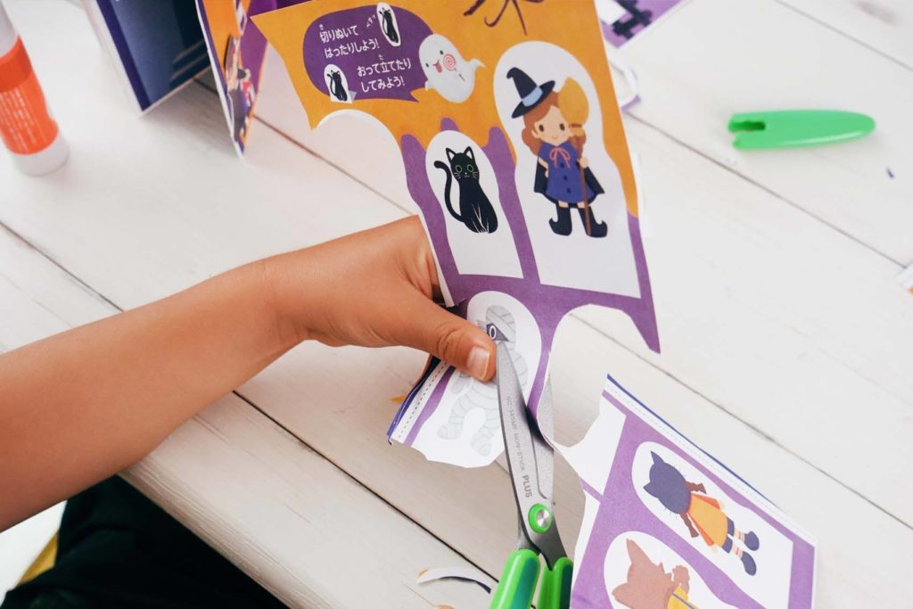 ハロウィン工作ブックを作る男の子の手元