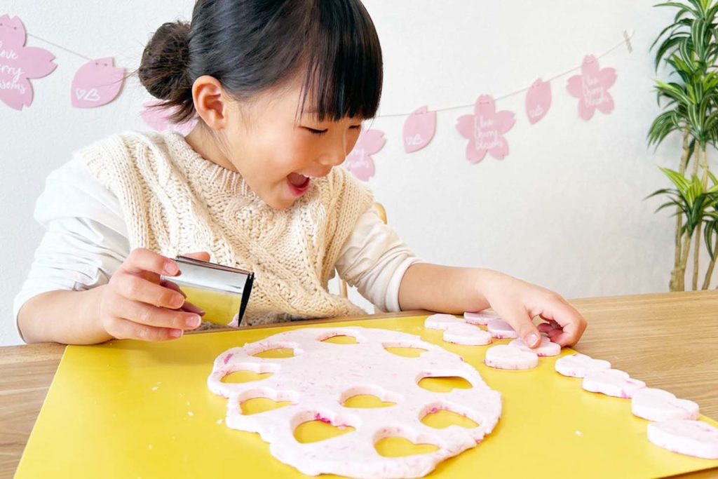 さくらマグネット工作にて、ハートの型抜きを使い粘土工作をする女の子
