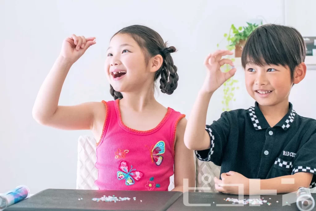 『クリスタル万華鏡』の鉱石を観察して笑顔の女の子と男の子