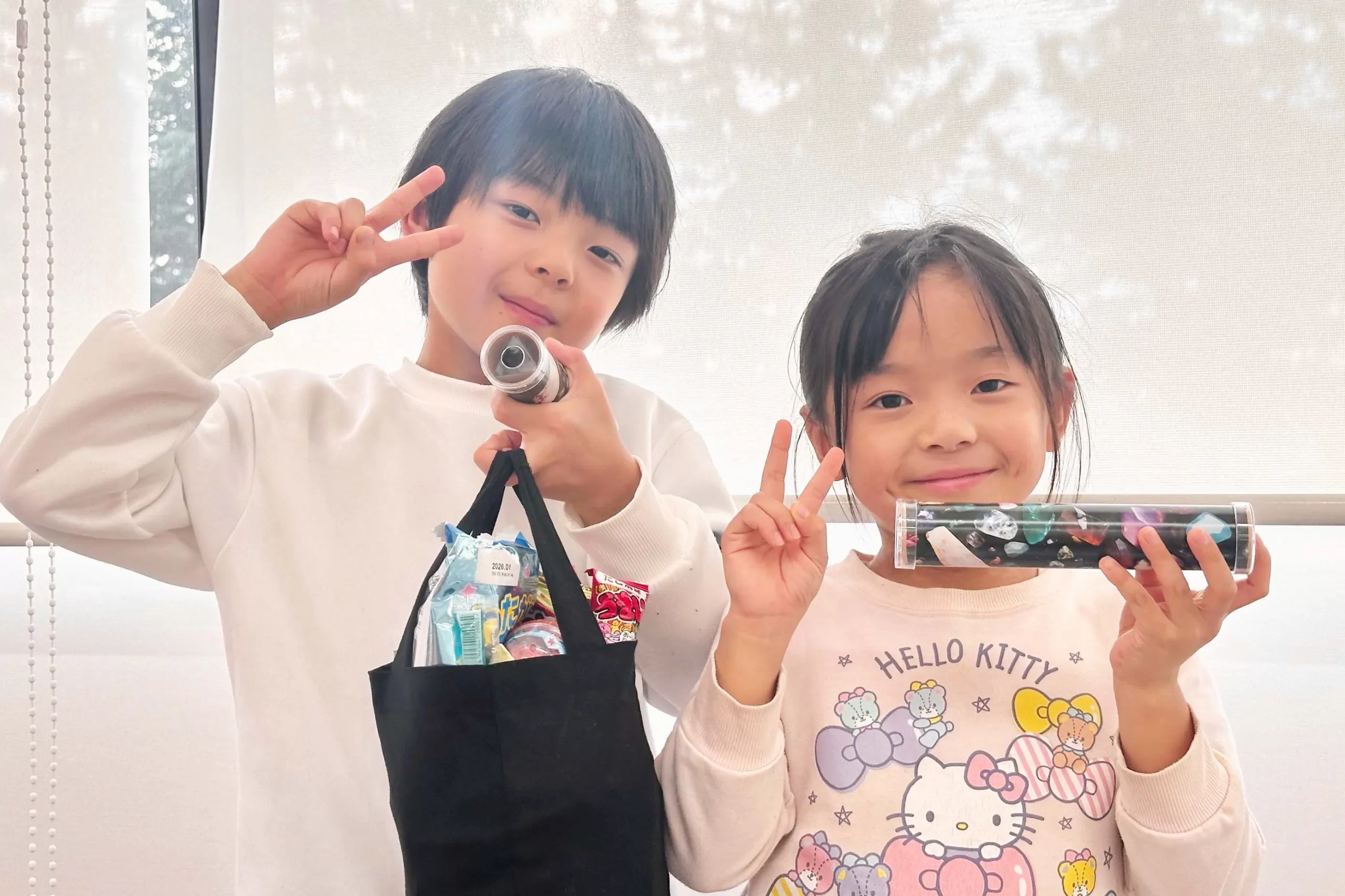 クリスタル万華鏡を手に持ちポーズをする兄妹