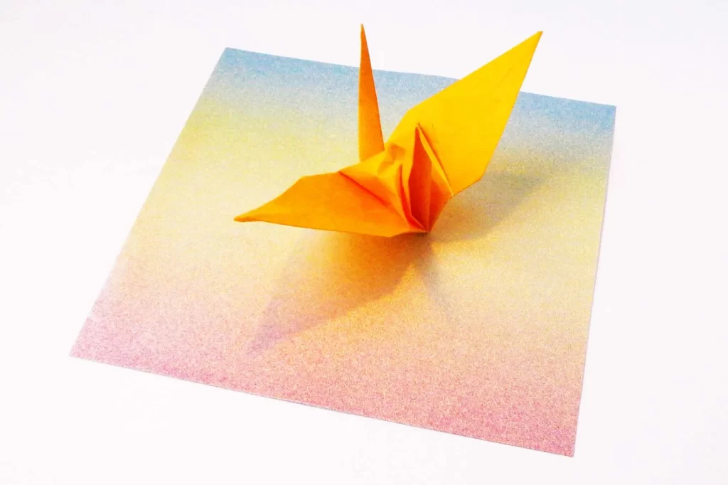 ダイソーの折り紙で作った鶴と『グリッターちよがみ レインボー』