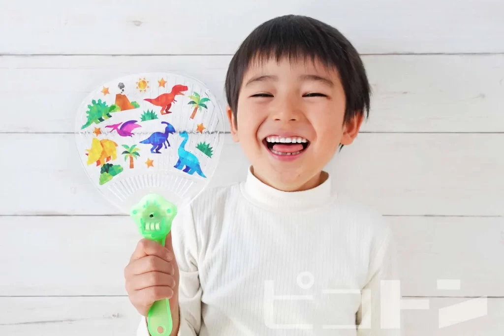 『光る！デコうちわ 恐竜ver.』を持つ笑顔の男の子