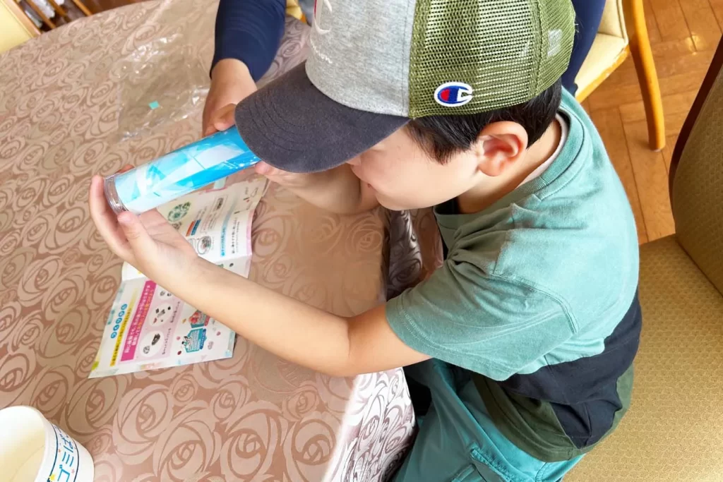 『クリスタル万華鏡』を覗き込む男の子