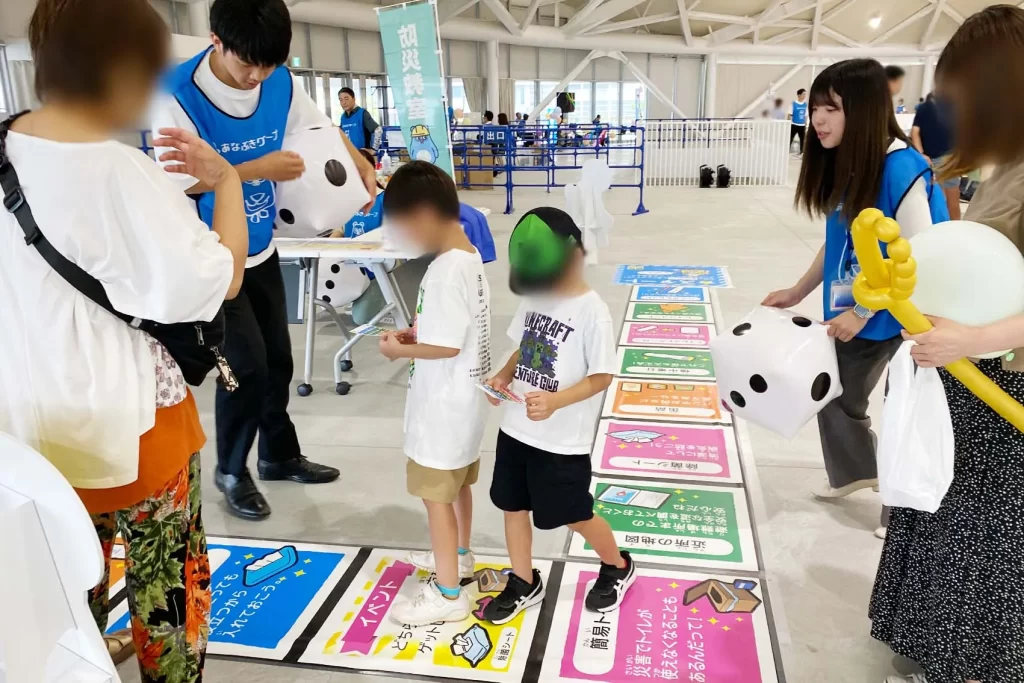 あなぶきハウジングで『巨大防災スゴロク』を体験する男の子と女の子