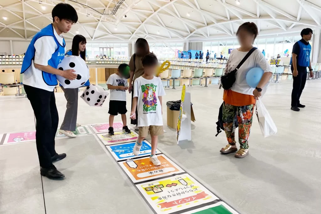 あなぶきハウジングで『巨大防災スゴロク』を体験する男の子たち