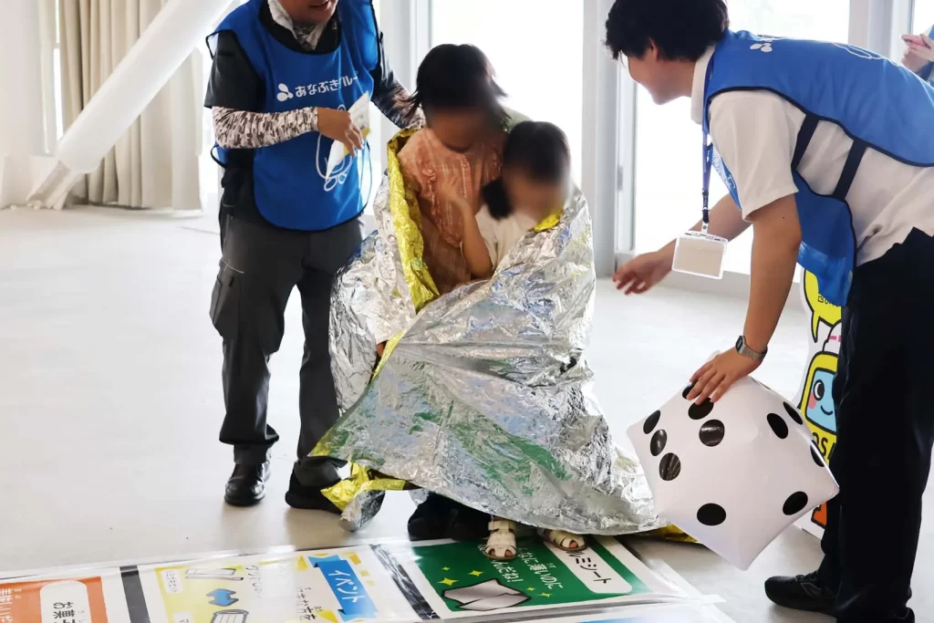 アルミシートにくるまれる姉妹