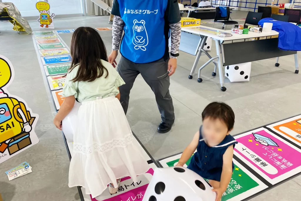 あなぶきハウジングで『巨大防災スゴロク』を体験する姉妹