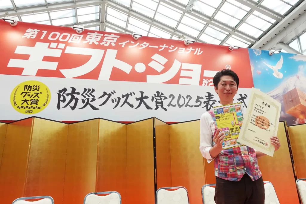 賞状と防災スゴロクを持つ株式会社ピコトン代表内木