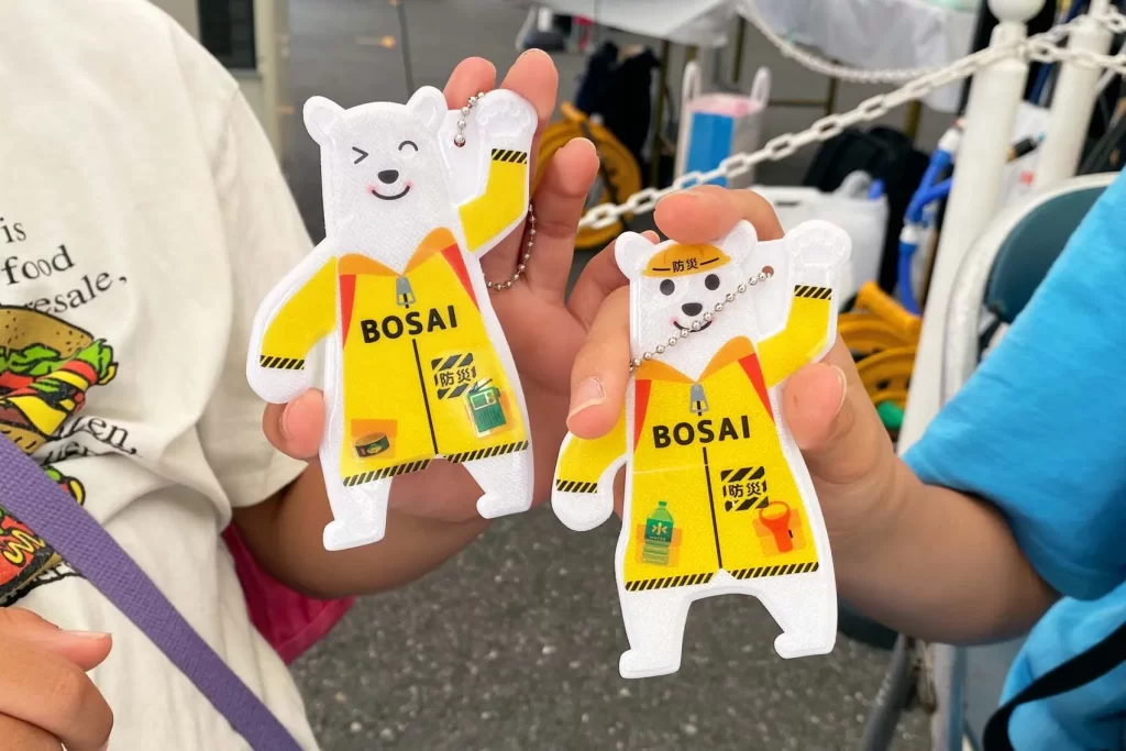 東京ガスライフバル足立で開催した『ピカッと!安全キーホルダー』の完成品2つを持つ兄弟