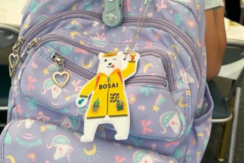 『ピカッと！安全キーホルダー』を紫のカバンにつけた様子