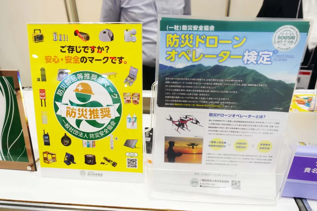 「危機管理産業展(RISCON TOKYO)」内、防災安全協会ブース。防災製品等推奨マーク、防災ドローンオペレーター検定