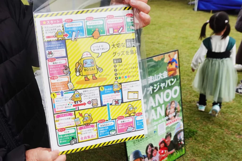 『防災スゴロク』を手に持つ様子