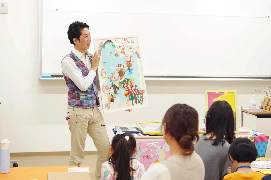 親子で楽しむアートフレーム工作ワークショップの手順を説明する講師
