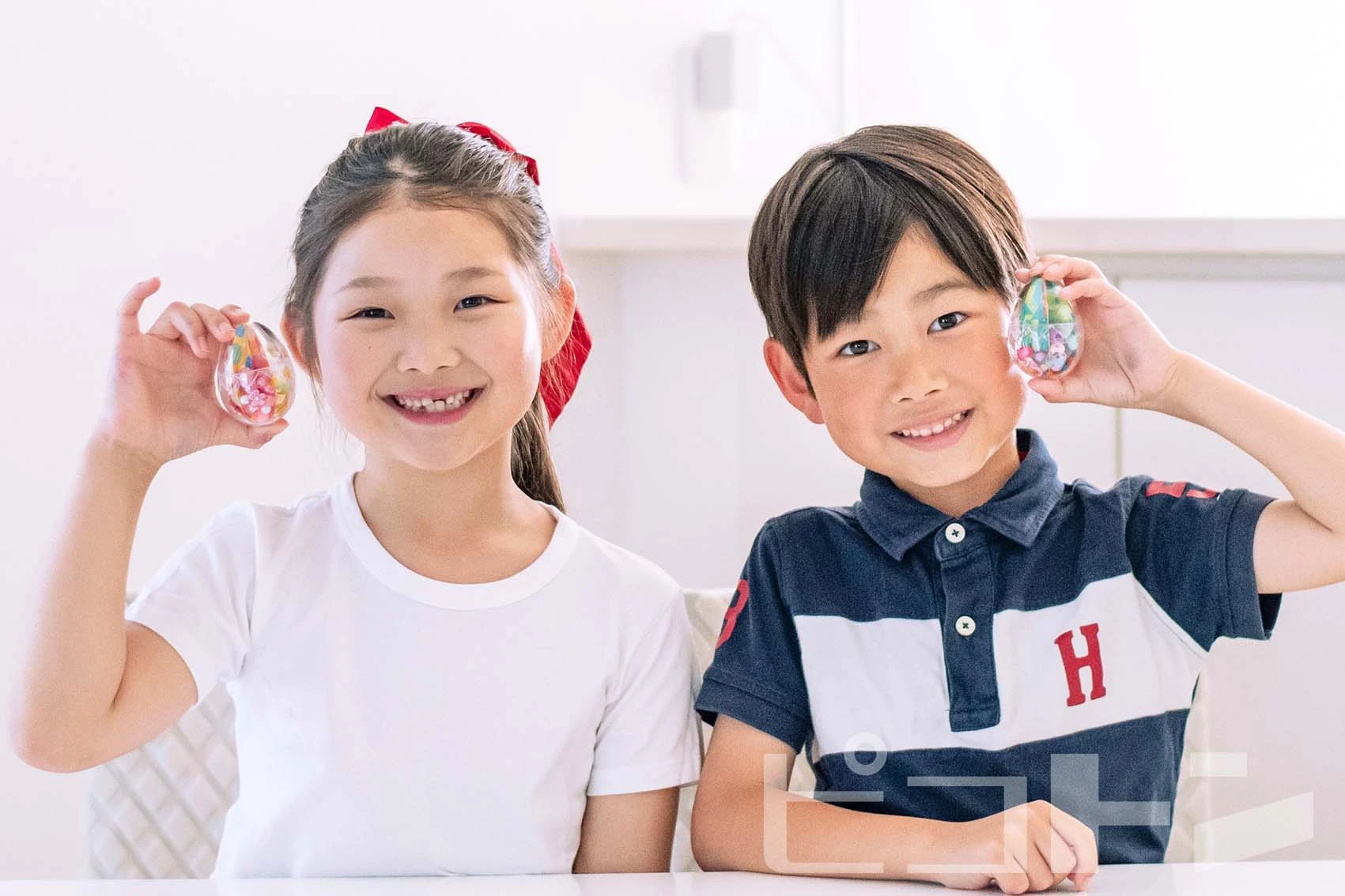 『エッグマラカス』の完成品を持ってポーズを取る女の子と男の子