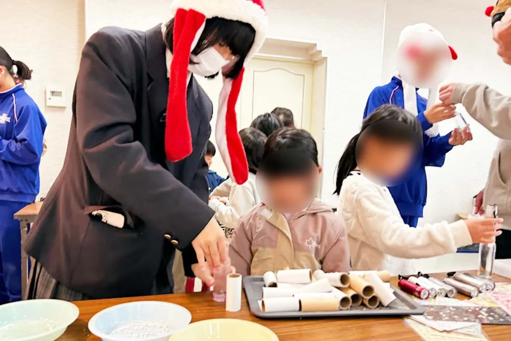 アントレプレナーシップ教育の一環として吉賀高等学校の学生が企画した交流イベントにて、子供たちと光る工作に取り組む様子