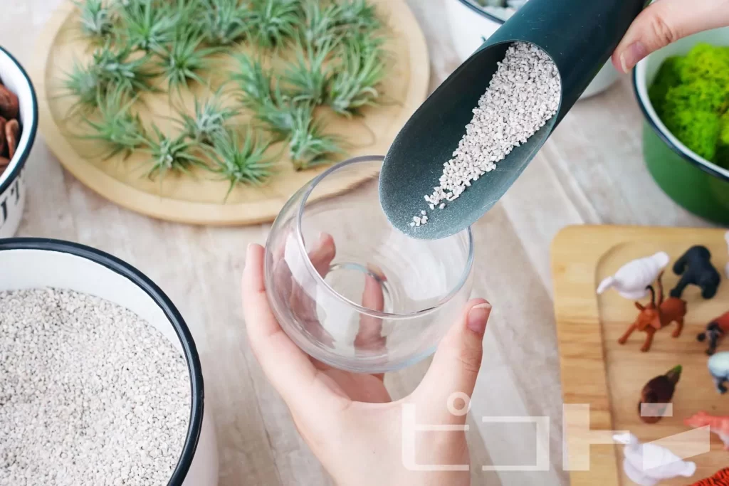 ガラスボールの中にサンゴ砂を入れます