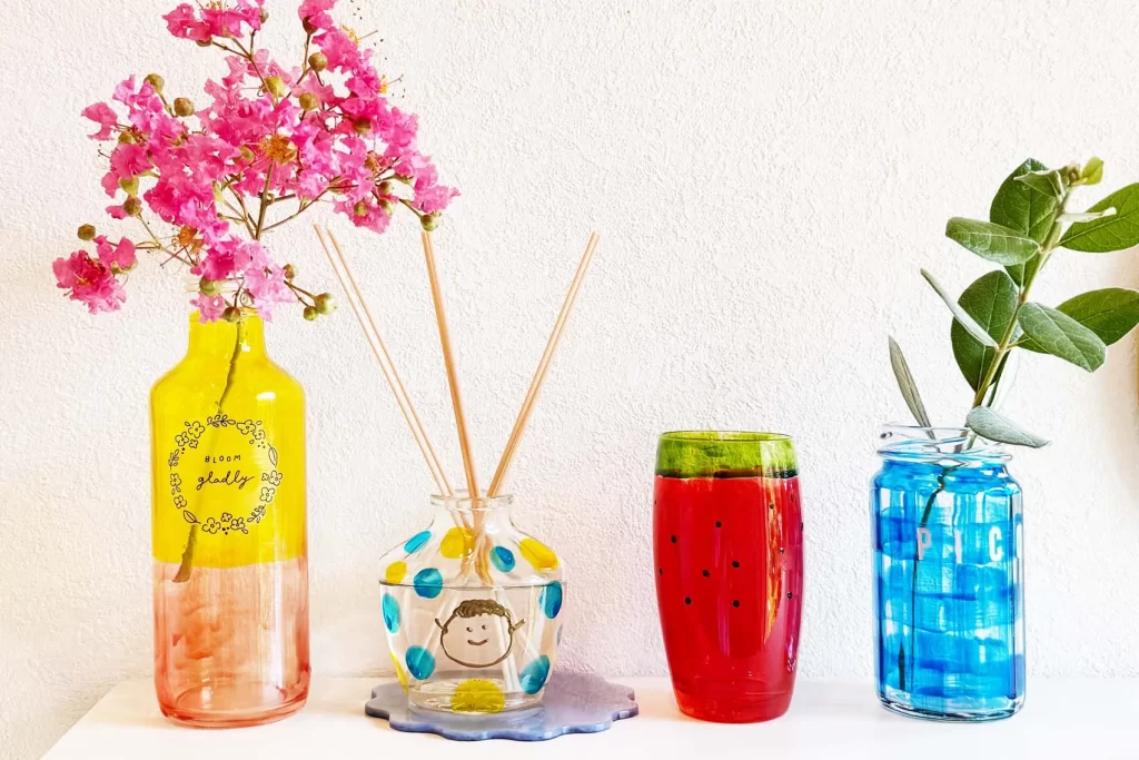 ガラス絵の具で彩色したアロマディフィーザーや瓶などの工作にお花を入れた様子