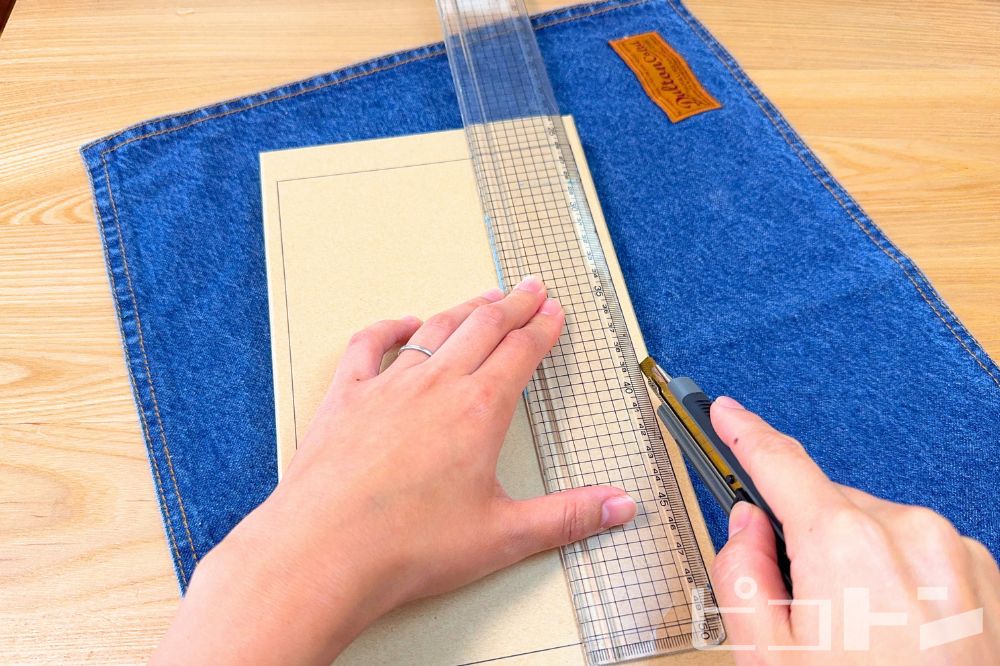 箱のフタをカッターで切っているところ