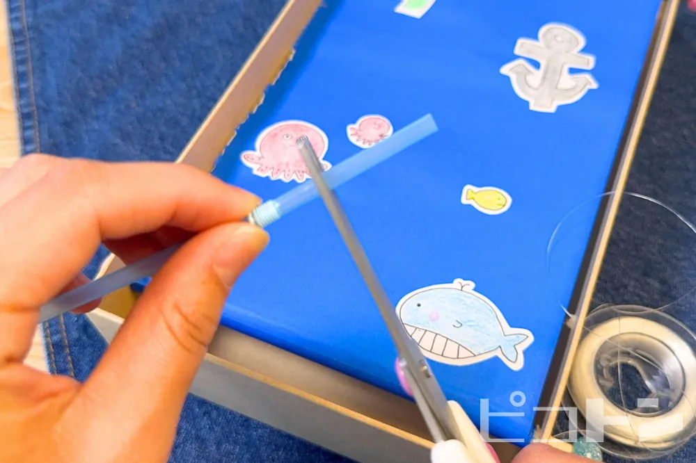 ストローをハサミで切っている