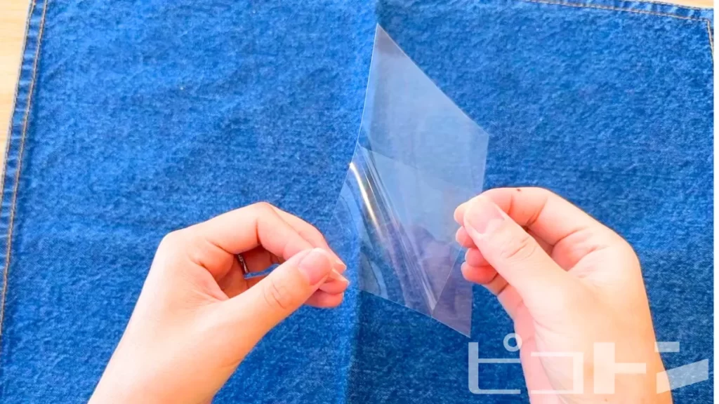 手貼りラミネートフィルムを剥がしている