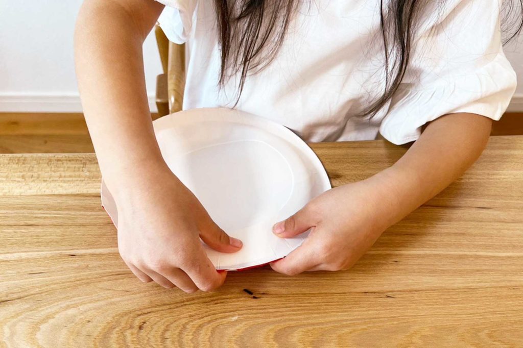 紙皿を折り曲げる女の子