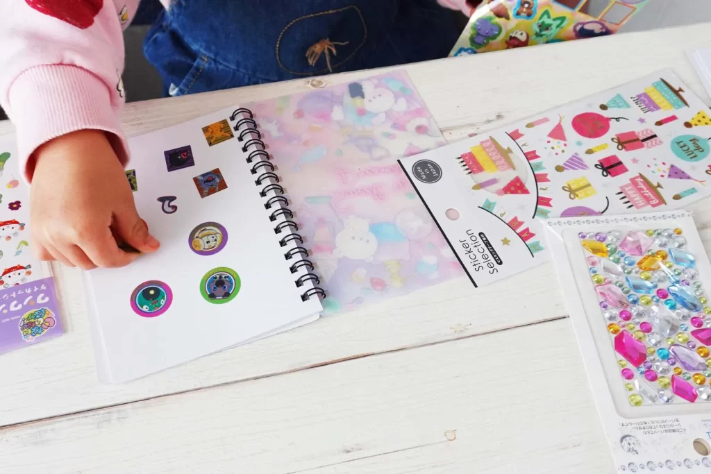 「１００均のシール帳」にシールを貼っているところ