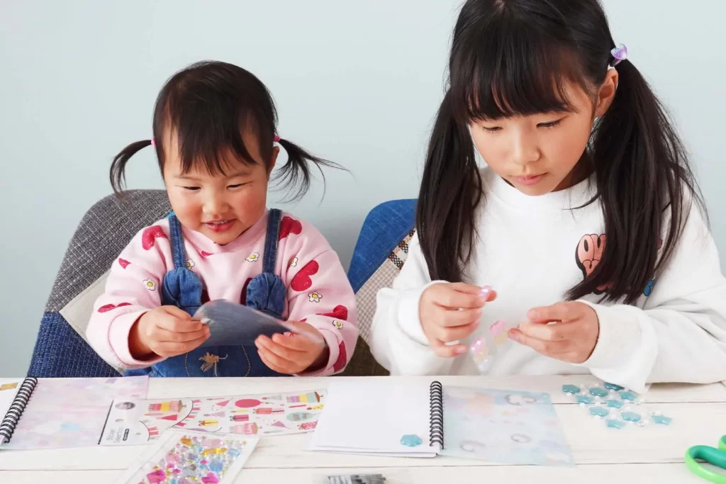 「100均のシール帳」に子どもたちがシールを貼る様子