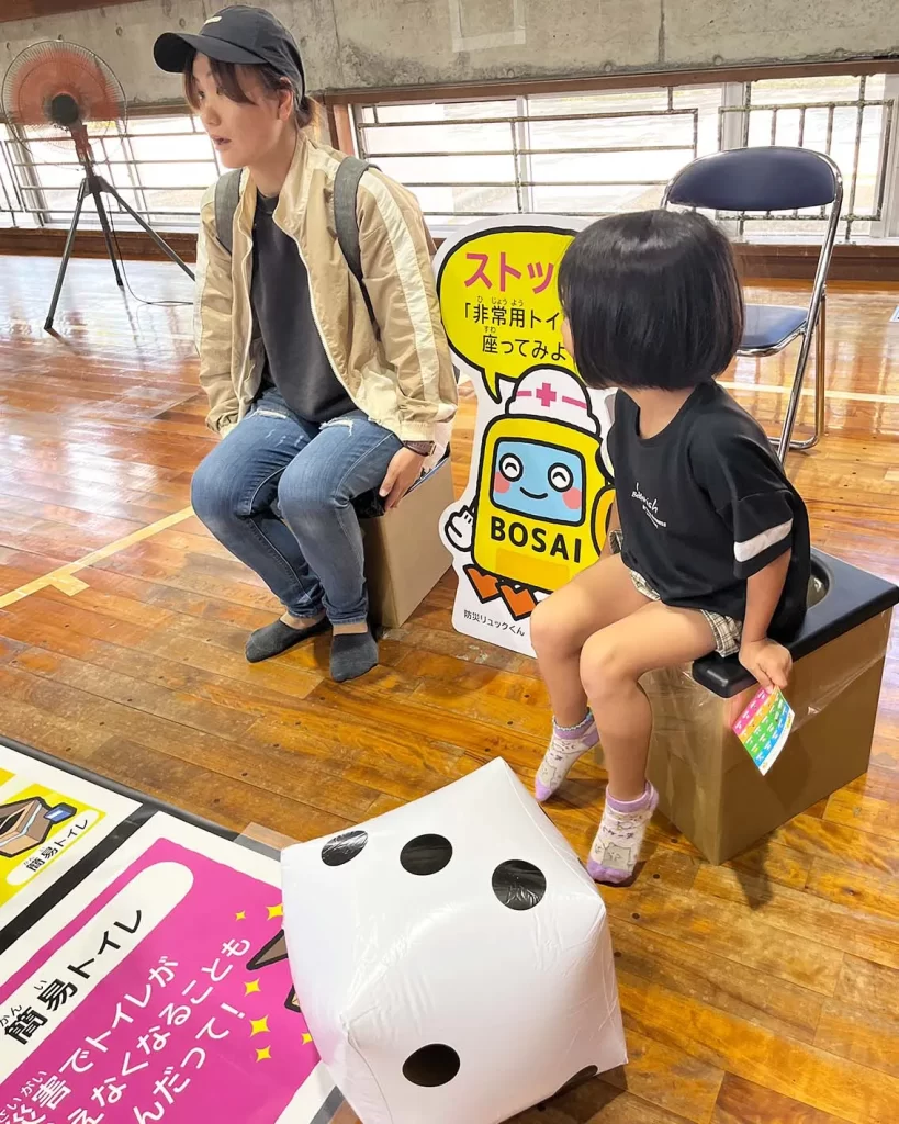 簡易トイレに座る親子