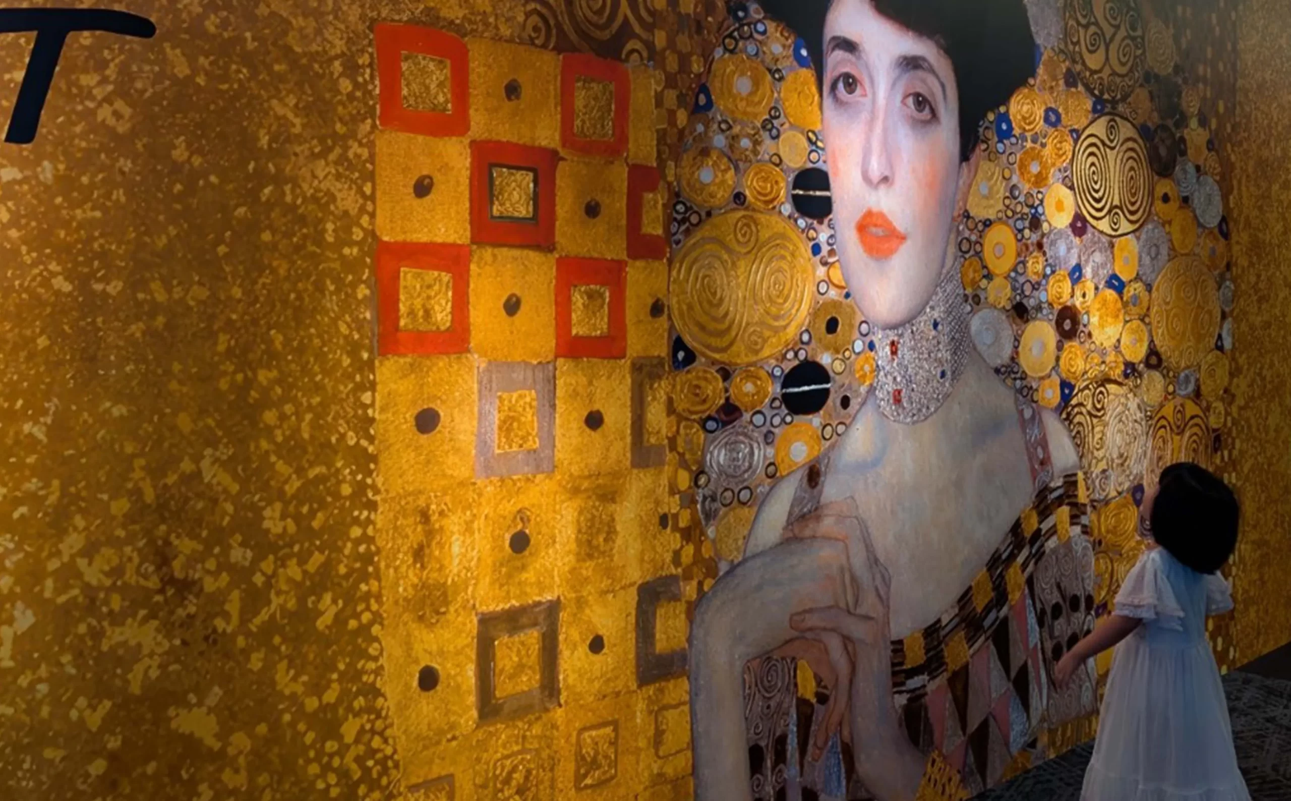 クリムト・アライブ 東京展の入口で壁面を見上げる女の子