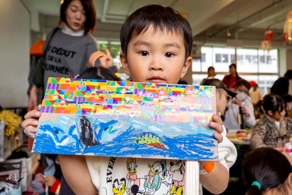 海の景色とカラフルな空の作品を持つ男の子