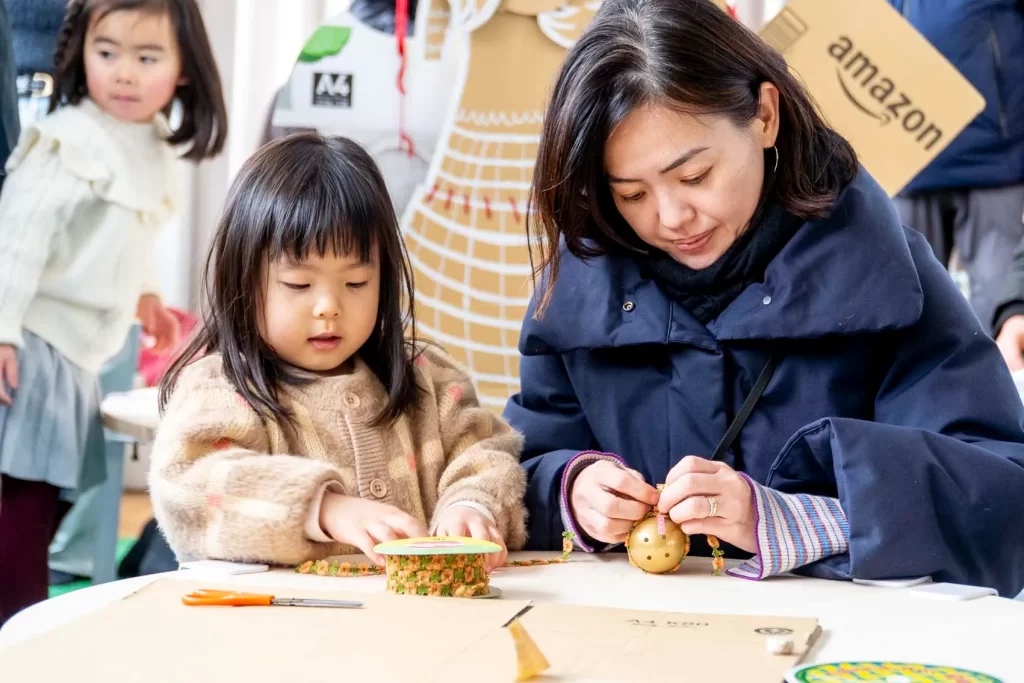 金のカプセルを使って工作する親子