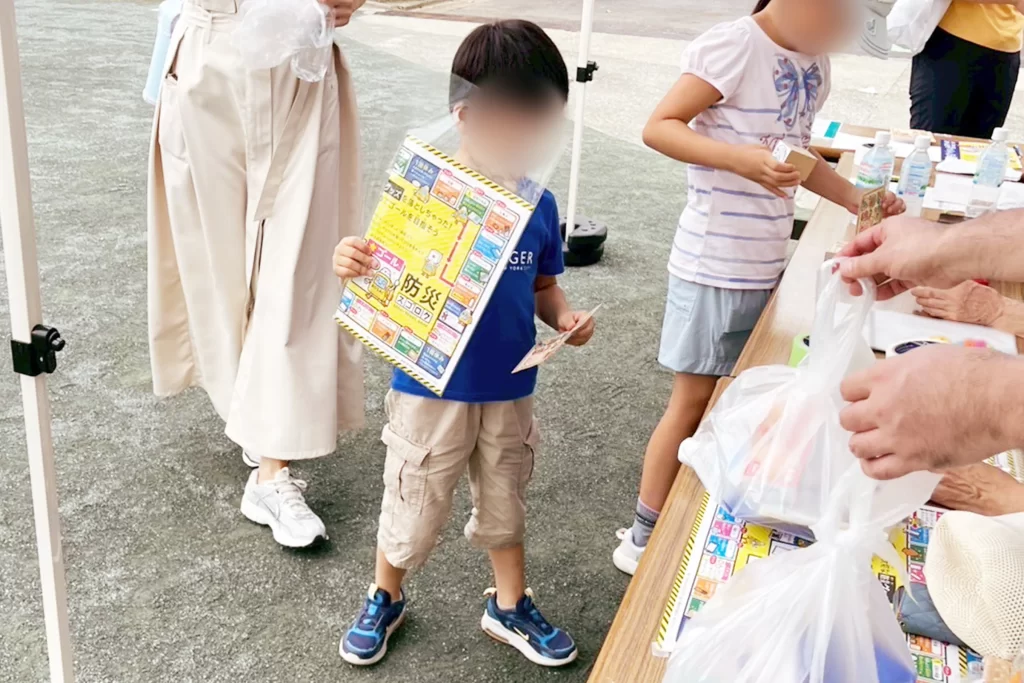 「駒場防災フェスタ』に参加し『防災スゴロク』を受け取った男の子と女の子