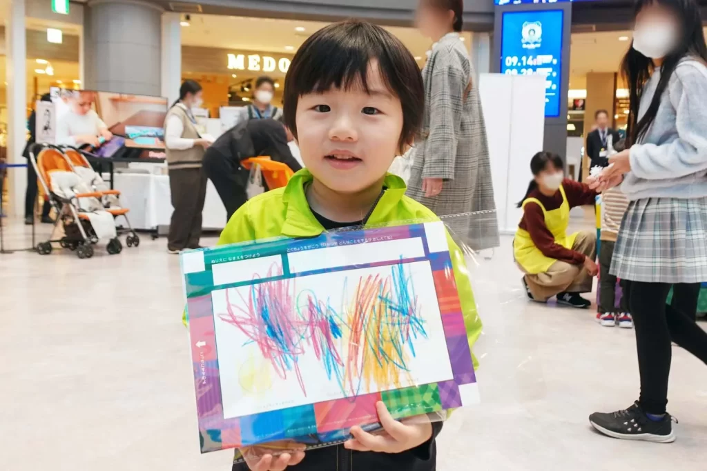 『うごく!シャッフルぬりえ』の完成品を持つ男の子