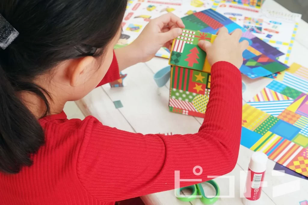 『Myおうちバッグクリスマスver.』の工作をする女の子(バッグをデコレーションする様子)