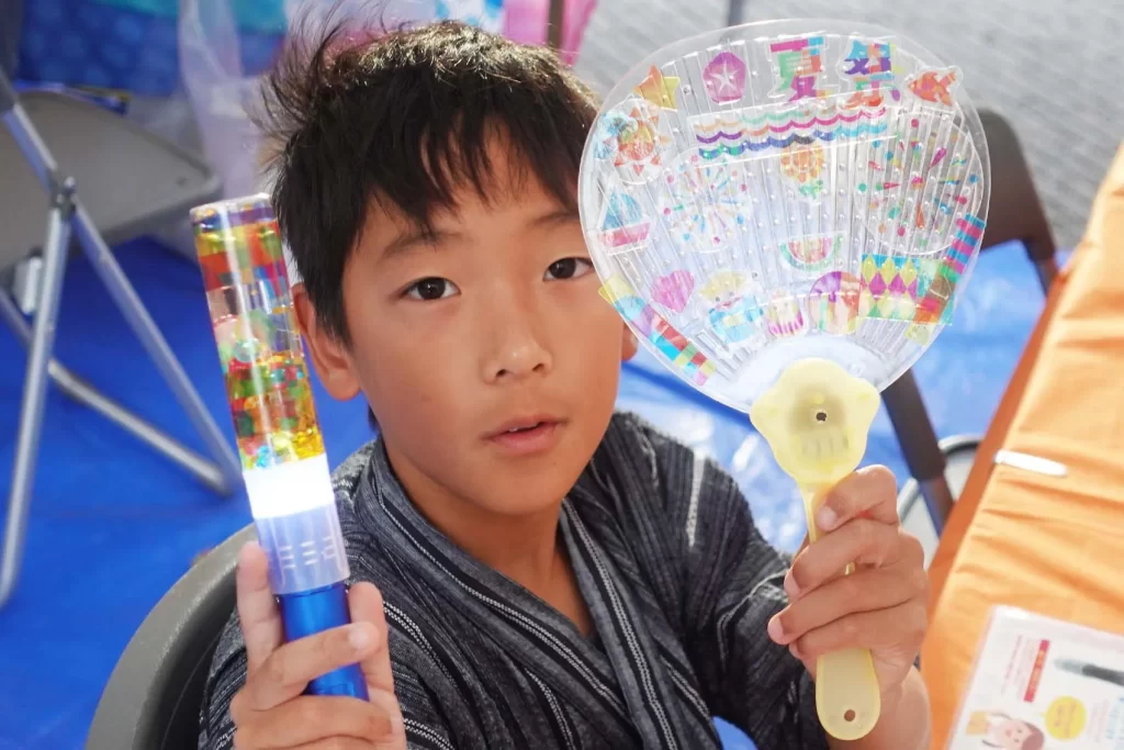 ナカボンver.の『光る!ウォータースティックライト』と『光る!デコうちわ』を持つ男の子②