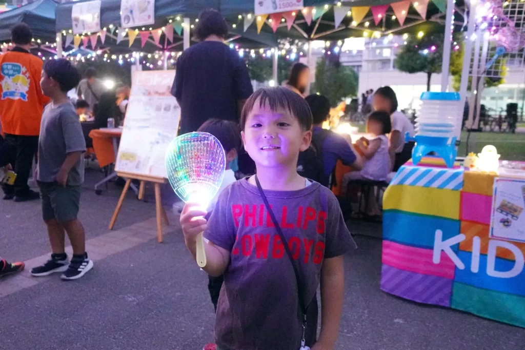 中野チルナイトピクニックにて完成した光る工作を持ってポーズを取る男の子